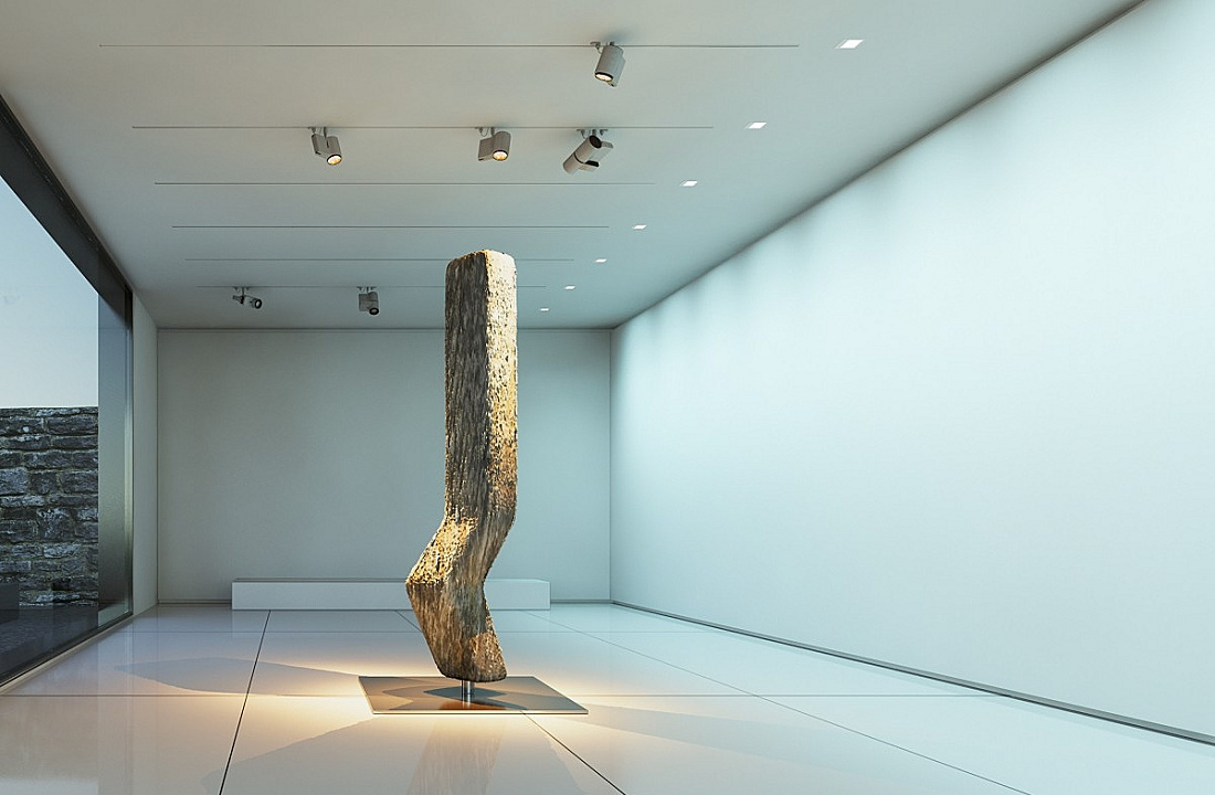 Illuminated wood sculpture in a gallery space, featuring ERCO spotlights for accent lighting.