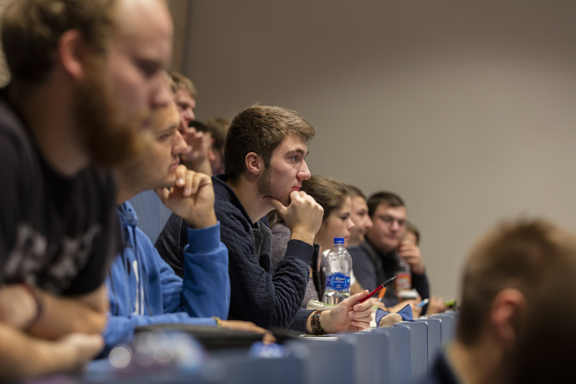 Students in a lecture hall at Neubrandenburg University under ERCO LED downlights.
