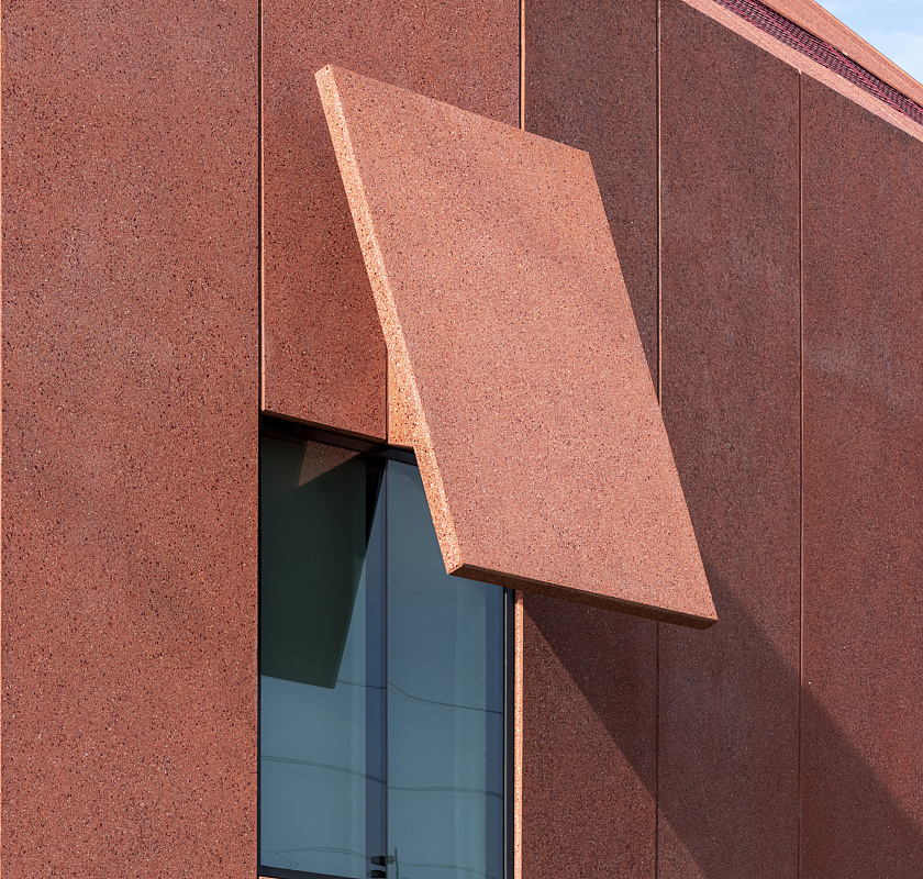 Close-up of Ruby City's facade featuring red concrete panels and a window detail.