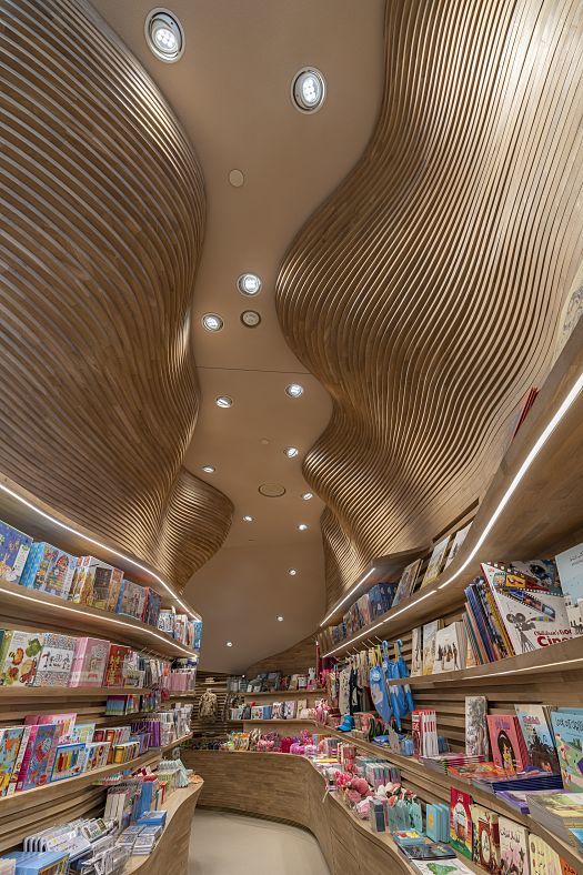 Childrens gift shop at the National Museum of Qatar, featuring ERCO lighting and wave-like wooden ceilings.