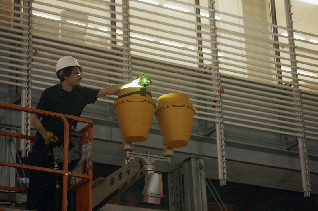 ERCO Beamer projectors being installed on the New York Times Building facade at night.