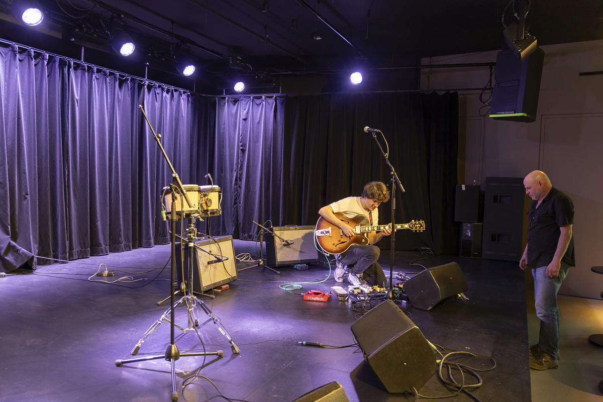 Guitarist on stage at NICA Jazz Club, Hamburg, lit by ERCO Optec New spotlights for an intimate atmosphere.