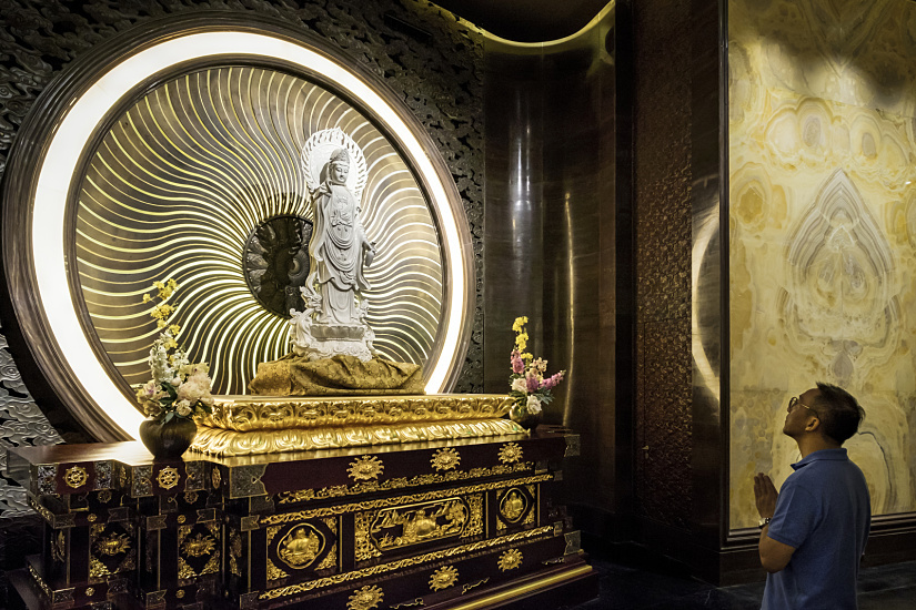 ERCO LED lighting at Niushoushan Culture Park, Nanjing, featuring a Buddha statue and visitor in contemplation.