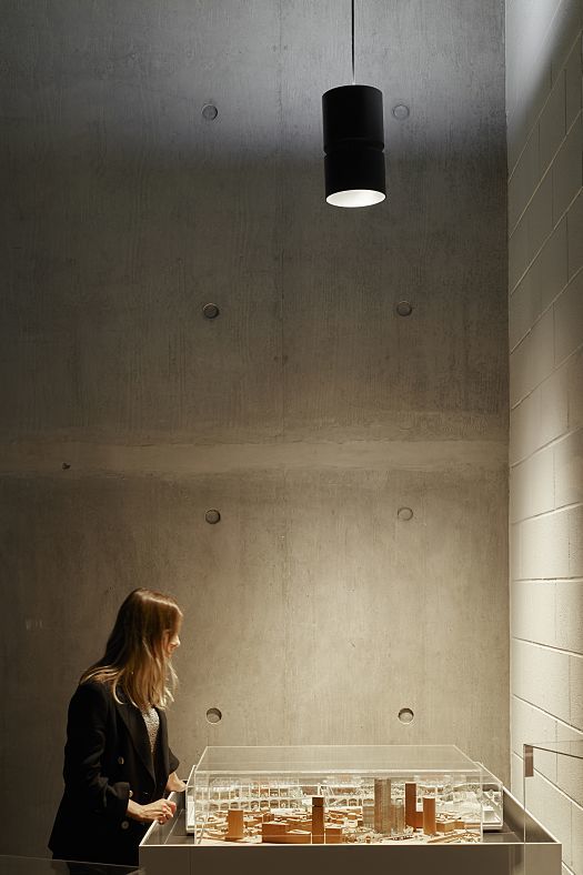 ERCO Atrium pendant in AHMM architects office, London. Flexible office lighting with concrete wall.