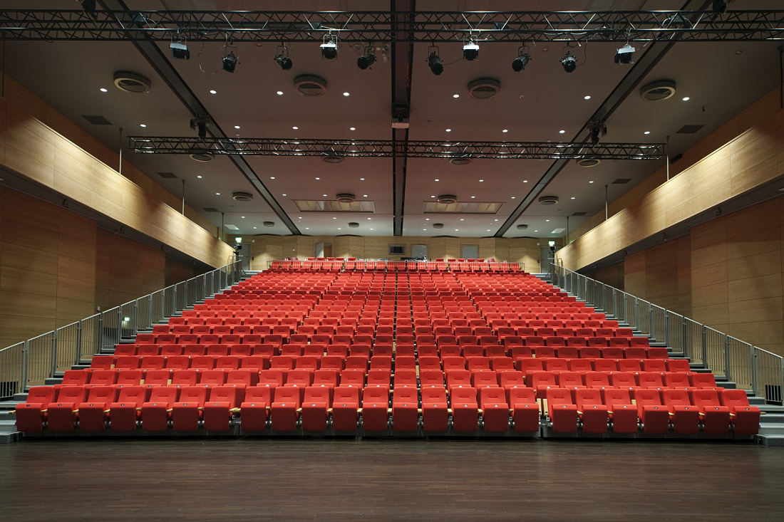 Oseana cultural center auditorium with ERCO LED lighting and red seating.