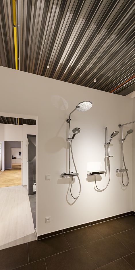 Shower fixtures in the Otto Wulff showroom, showcased with ERCO LED lighting for high-quality material selection.