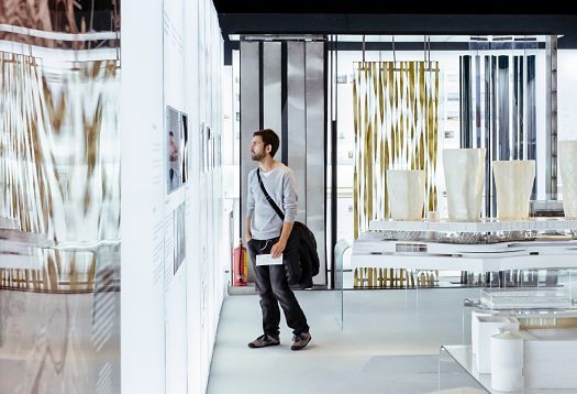 Visitor views architectural designs at Palau Robert, illuminated by ERCO spotlights.