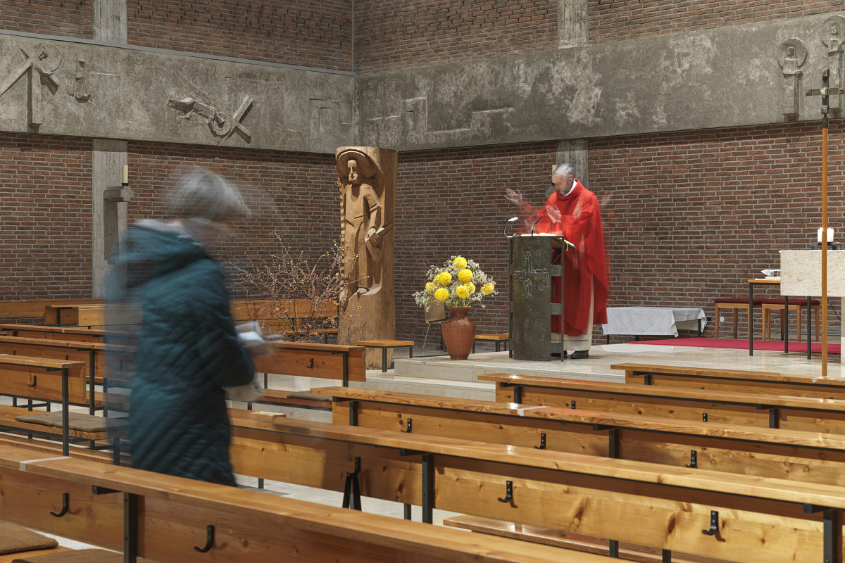 Priest at St. Joseph Church in Karlsfeld, illuminated by ERCO Atrium pendant luminaires and Parscan spotlights.