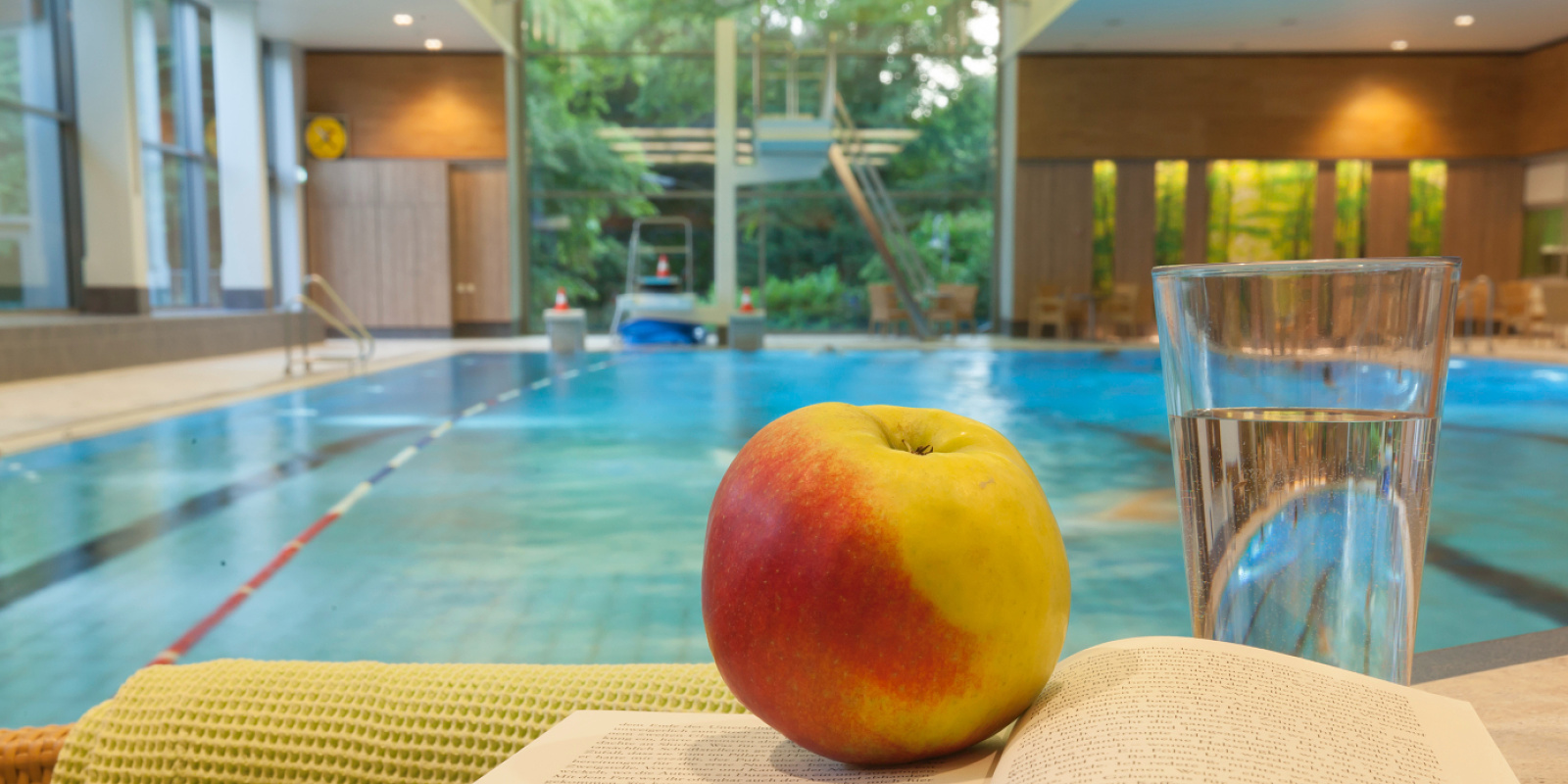 Apple and water glass at Parkbad Volksdorf, Hamburg. Relaxation after swimming.