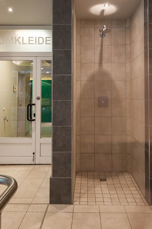 Tiled shower in Parkbad Volksdorf, illuminated by ERCO Compact downlights for optimal color rendering.