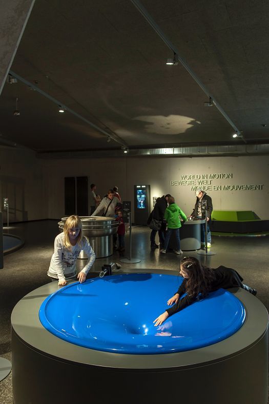 Children interact with an exhibit at Phänomenta Science Center, lit by ERCO lighting.