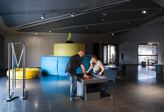 Visitors interact with exhibits at Phänomenta Science Center, illuminated by ERCO lighting.