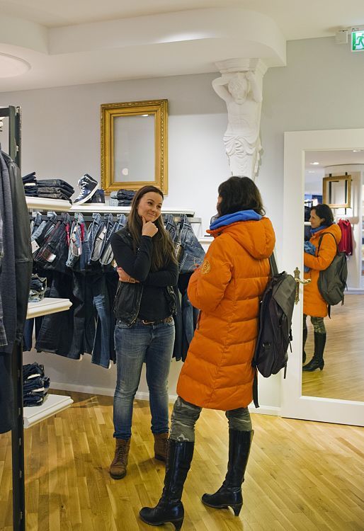 Customers in Pier14 concept store, Zinnowitz, illuminated by ERCO Optec spotlights and Quintessence luminaires.