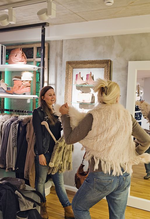 Customers selecting apparel at Pier14 concept store, illuminated by ERCO Optec spotlights.