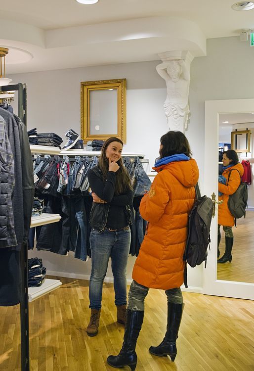 Customers in Pier14 concept store, Zinnowitz, illuminated by ERCO Optec spotlights and Quintessence luminaires.