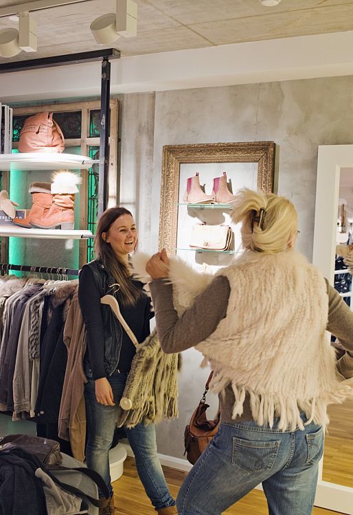 Customers selecting apparel at Pier14 concept store, illuminated by ERCO Optec spotlights.