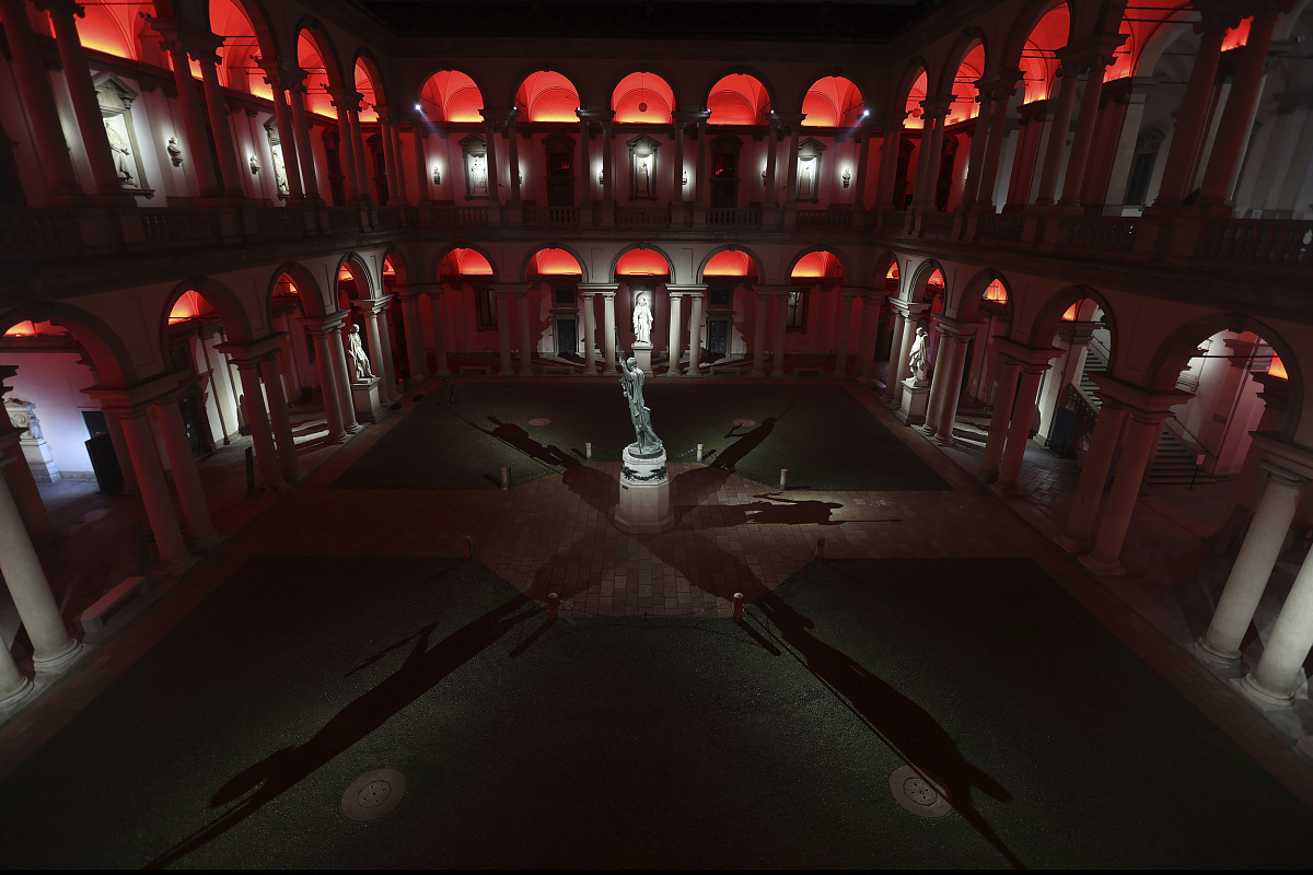 Pinacoteca di Brera courtyard illuminated with red LED lighting, enhancing architectural details.