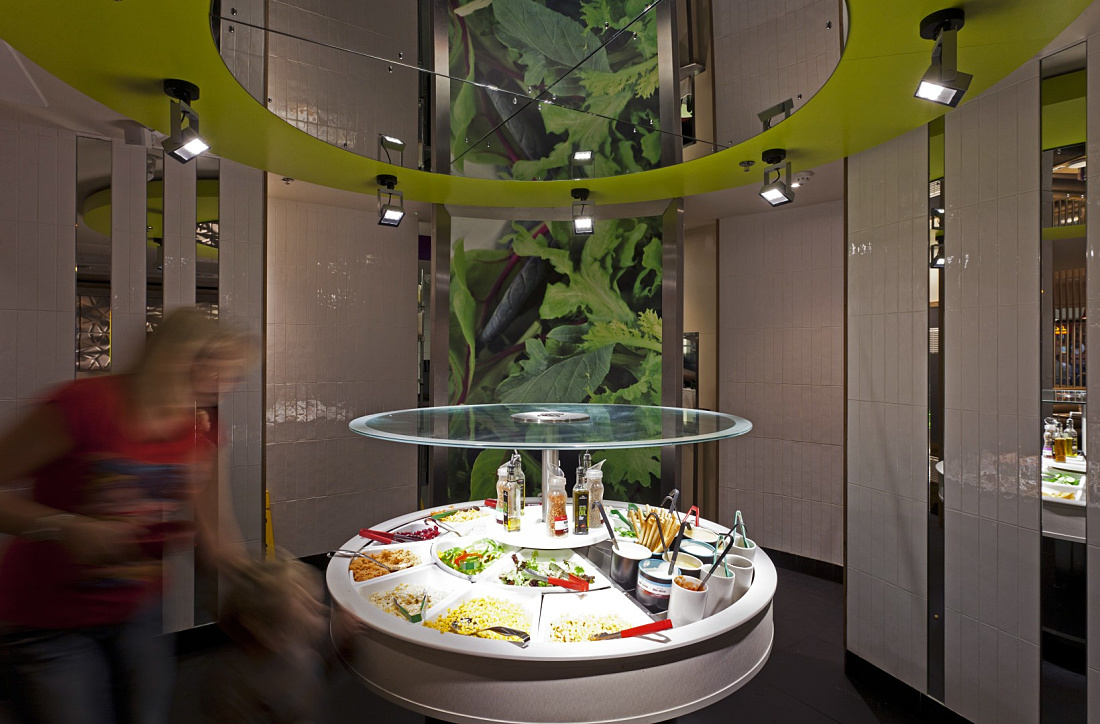 Illuminated salad bar area in a Pizza Hut restaurant, featuring ERCO LED spotlights for accent lighting.