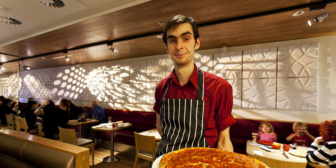 Pizza Hut restaurant featuring ERCO LED lighting, server with pizza.