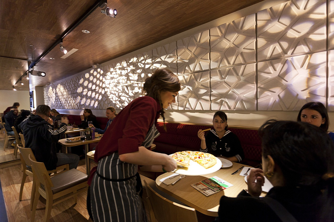 Pizza Hut restaurant interior featuring ERCO LED spotlights and diners.