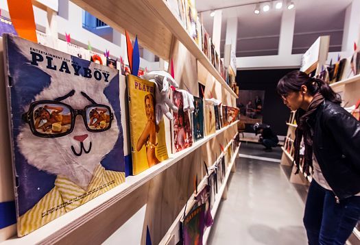 Visitor views vintage Playboy magazines at the German Architecture Museum exhibition.