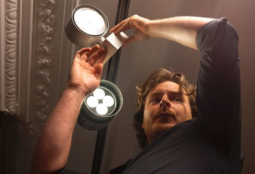 Matthew Penn adjusting ERCO LED spotlights to enhance his paintings.