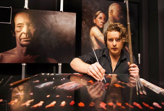 Matthew Penn in his studio, painting hyper-realistic portraits with ERCO lighting.