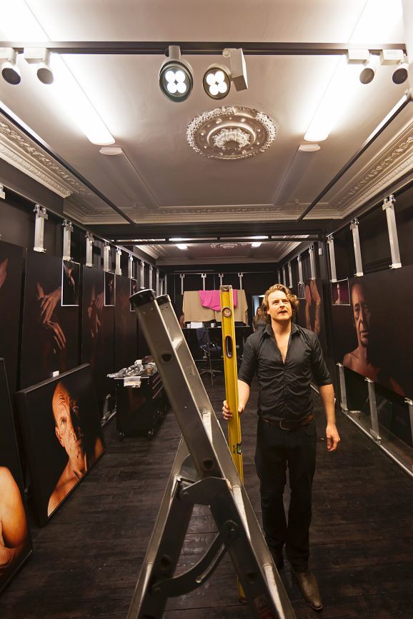 Matthew Penn in his studio with ERCO LED spotlights illuminating his photorealistic portraits.