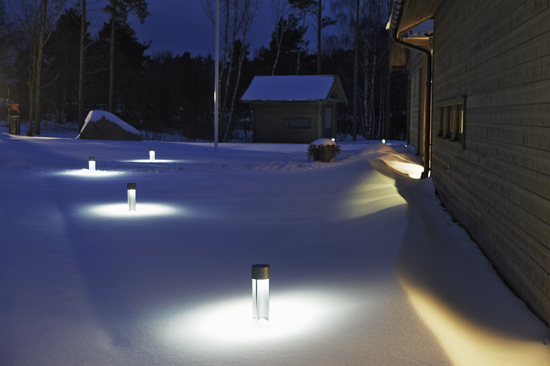 Midipoll bollard lights illuminate a snowy garden path, providing Dark Sky lighting.