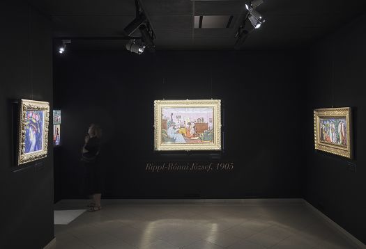 Gallery view with paintings precisely highlighted by directed light projection.