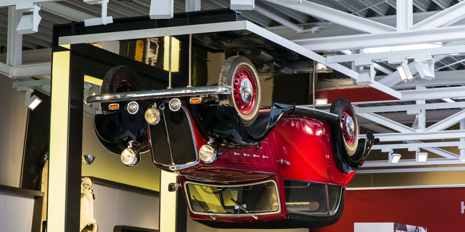 Inverted vintage car display at PS.Speicher Museum, illuminated by ERCO LED spotlights.