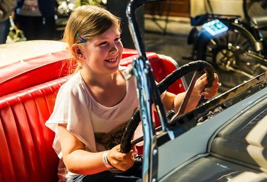 Girl at the wheel of a vintage car in the PS.Speicher Museum, Einbeck.
