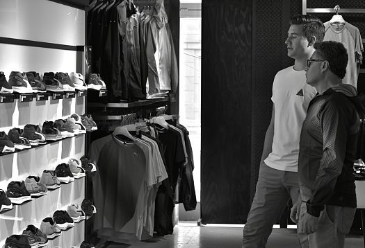 Customers in PUMA store, Berlin, illuminated by ERCO Optec spotlights highlighting goods and areas.