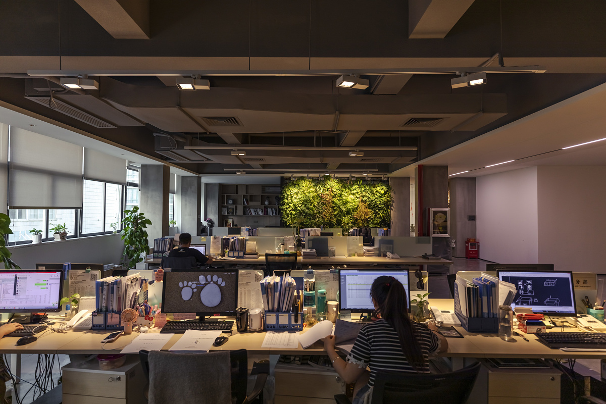 ERCO Optec spotlights illuminate a vertical plant wall in the modern Qiguang Technology office.