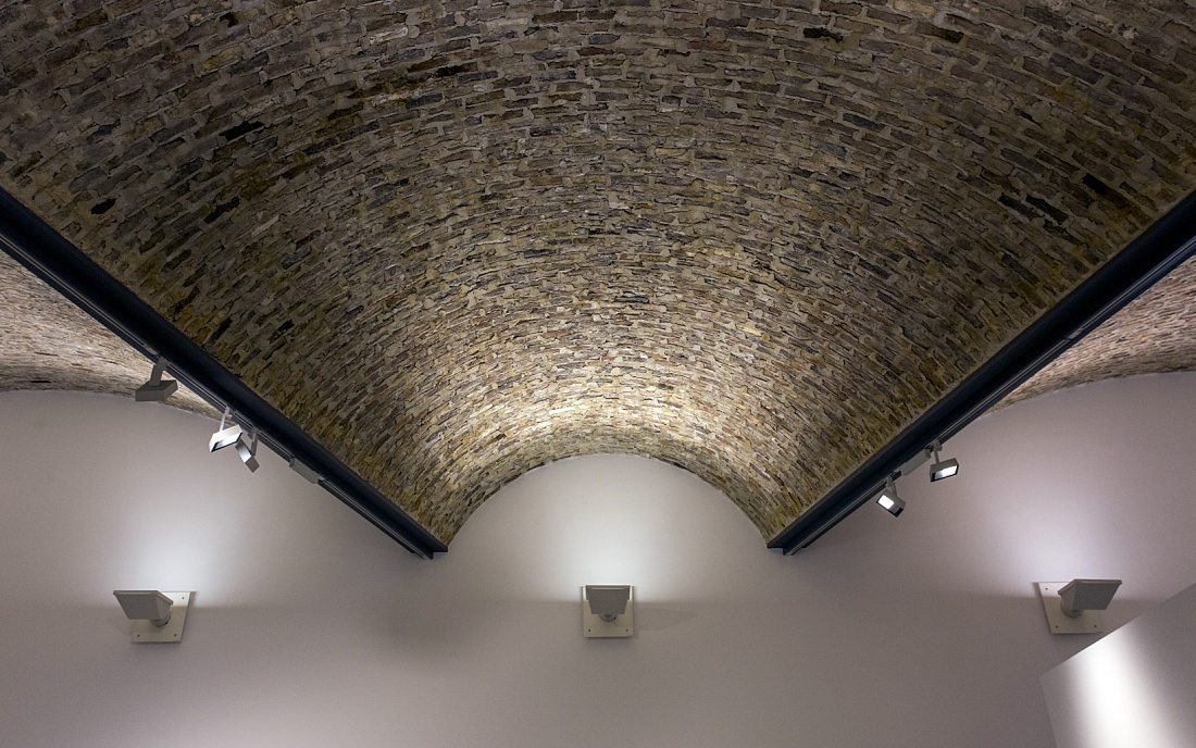 Vaulted ceiling with Optec spotlights in Ravensburg Art Museum, illuminated for exhibitions.