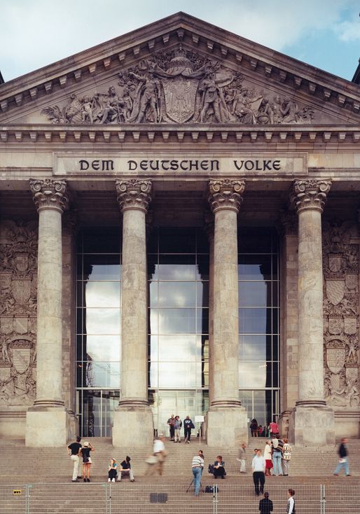 The Reichstag Building in Berlin, seat of the German Bundestag, with visitors on the steps.