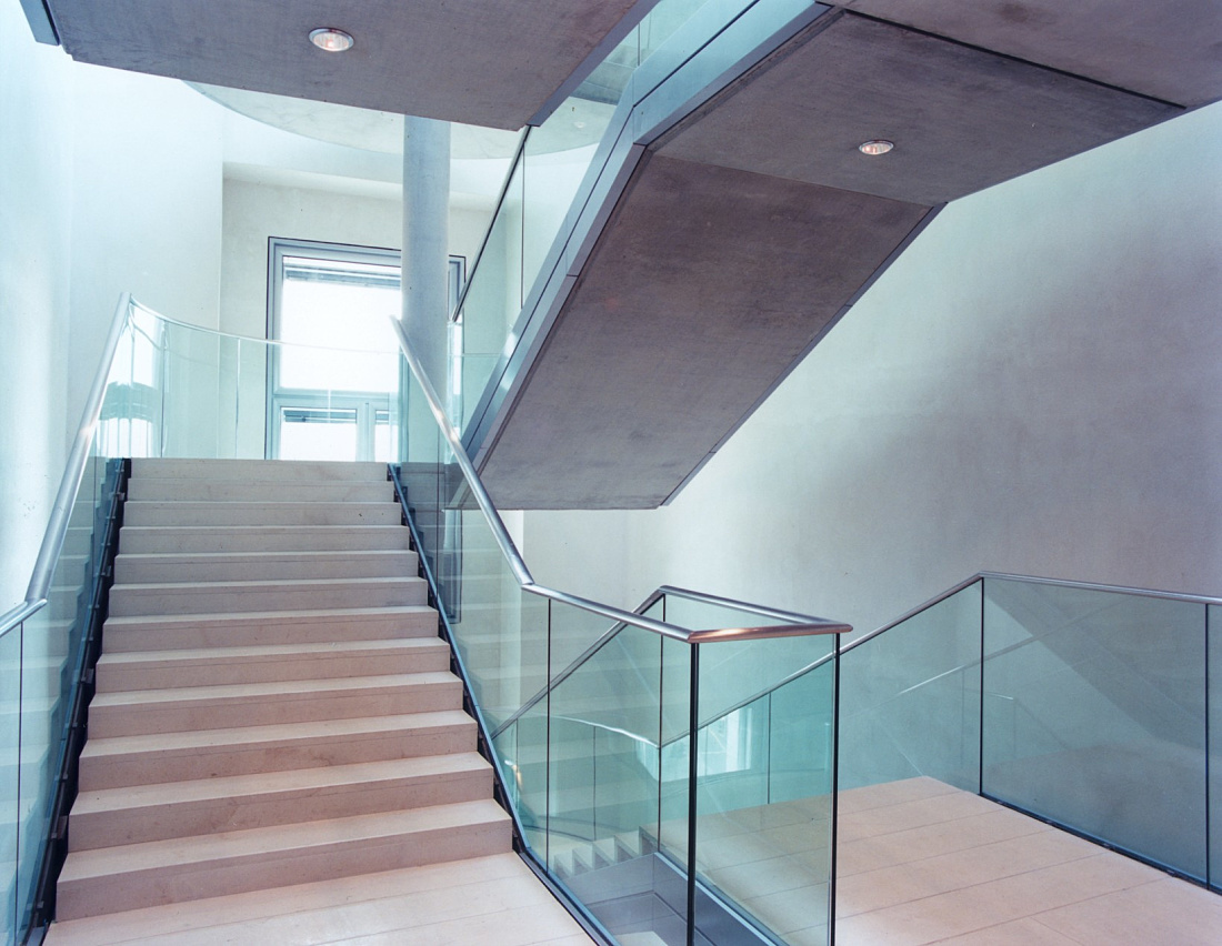Staircase in the Reichstag Building featuring glass railings and ERCO lighting.