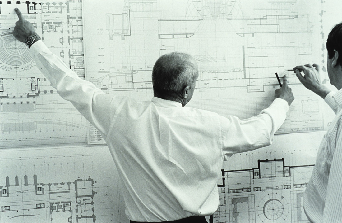 Architects reviewing Reichstag building plans, Berlin, showcasing ERCO lighting project.