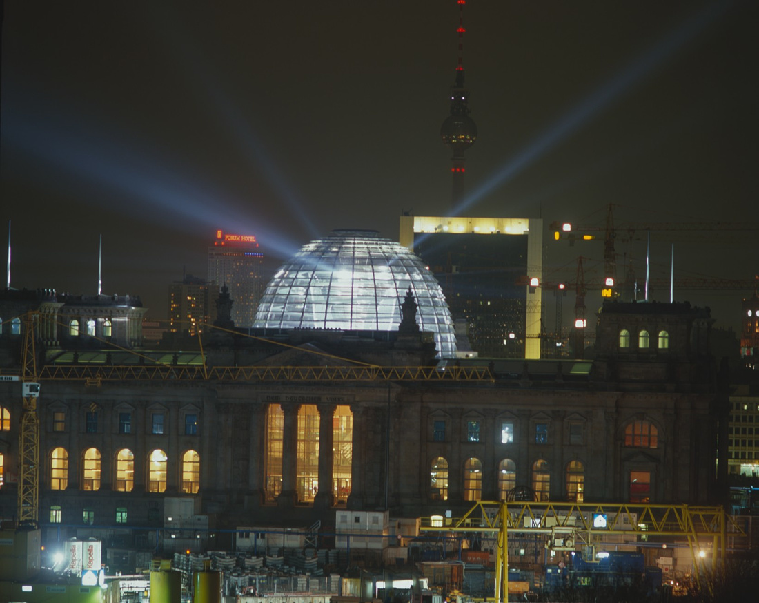 Illuminated Reichstag dome in Berlin at night, showcasing German architecture and ERCO lighting.