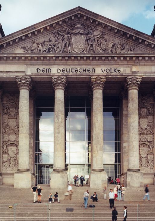 The Reichstag Building in Berlin, seat of the German Bundestag, with visitors on the steps.