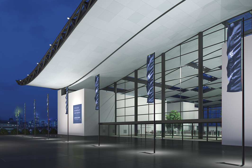 Illuminated public building with glass facade and flags, creating orientation and a welcoming atmosphere.
