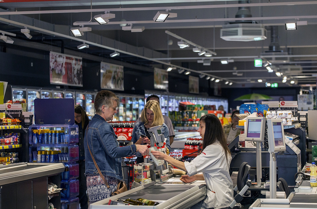 REWE supermarket checkout with Opton LED accent lighting for energy efficiency.