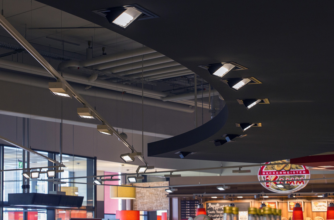 ERCO Opton LED spotlights in a REWE supermarket, providing energy-efficient accent lighting.