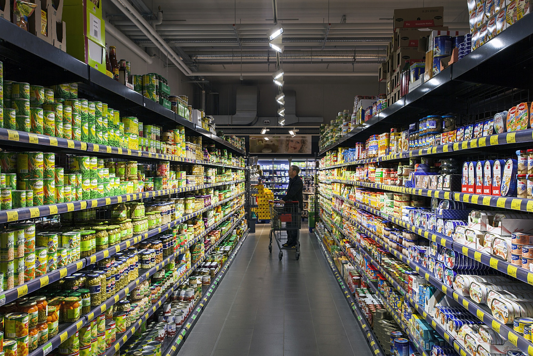 REWE supermarket aisle featuring Opton LED accent lighting for energy-efficient shopping.