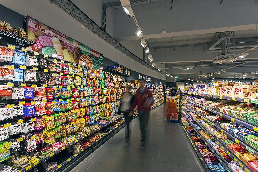 REWE supermarket in Hagen-Hohenlimburg featuring Opton LED accent lighting on candy shelves.