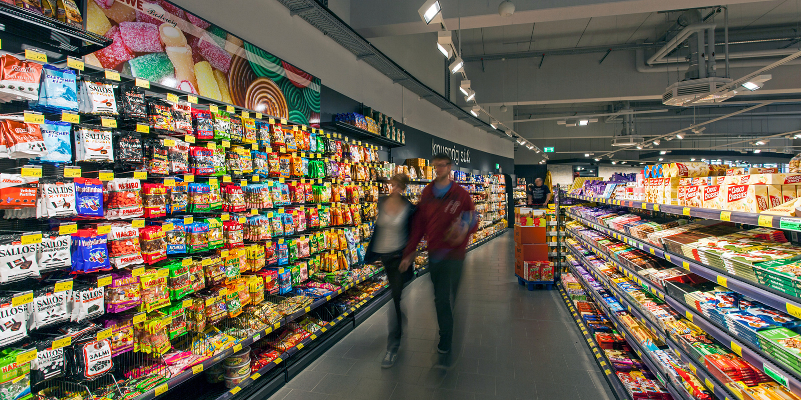 REWE supermarket in Hagen-Hohenlimburg featuring LED accent lighting to highlight products.