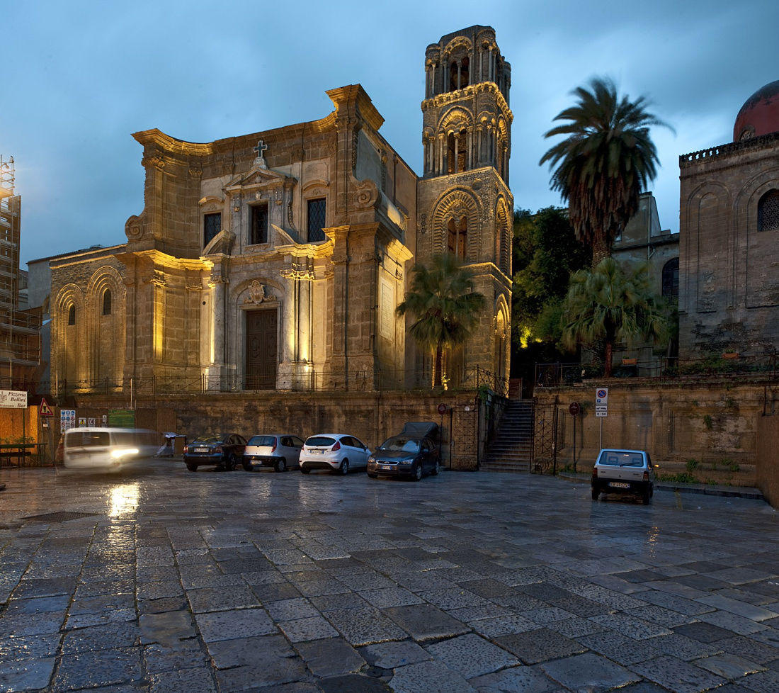 Illuminated Santa Maria dell’Ammiraglio church in Palermo, known for its ornamented ceilings.