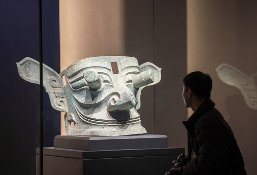 Sanxingdui Museum bronze mask illuminated by ERCO LED lighting for cultural preservation.