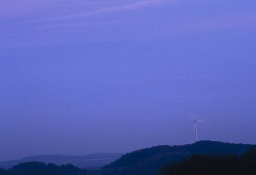 Wind turbine on a hill at night, demonstrating scotopic vision.