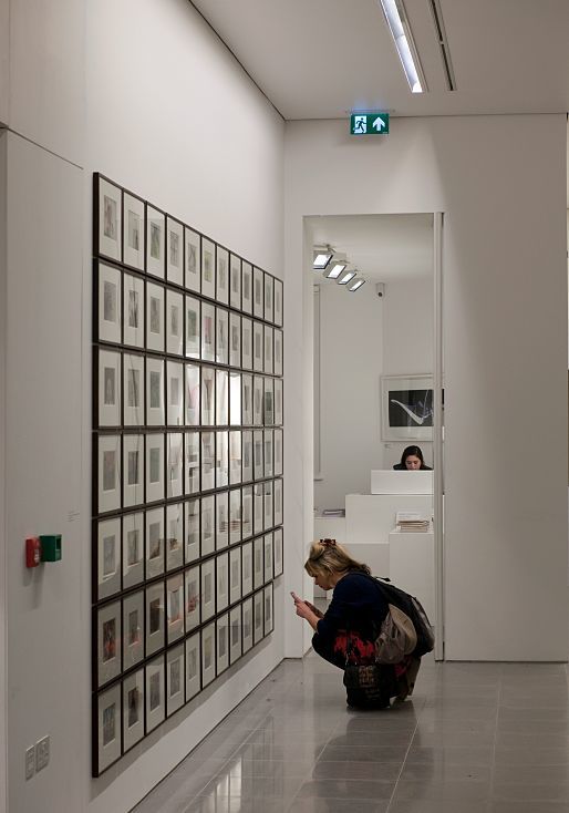 Visitor views art at the Serpentine Sackler Gallery, illuminated by ERCO lighting.